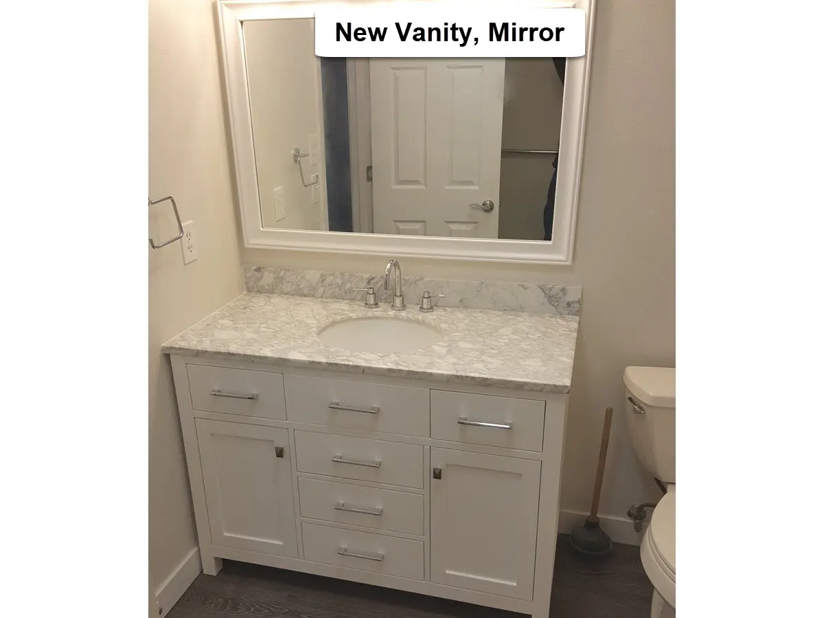Bathroom vanity and mirror installation in Tigard showing new vanity cabinet with countertop and framed wall mirror